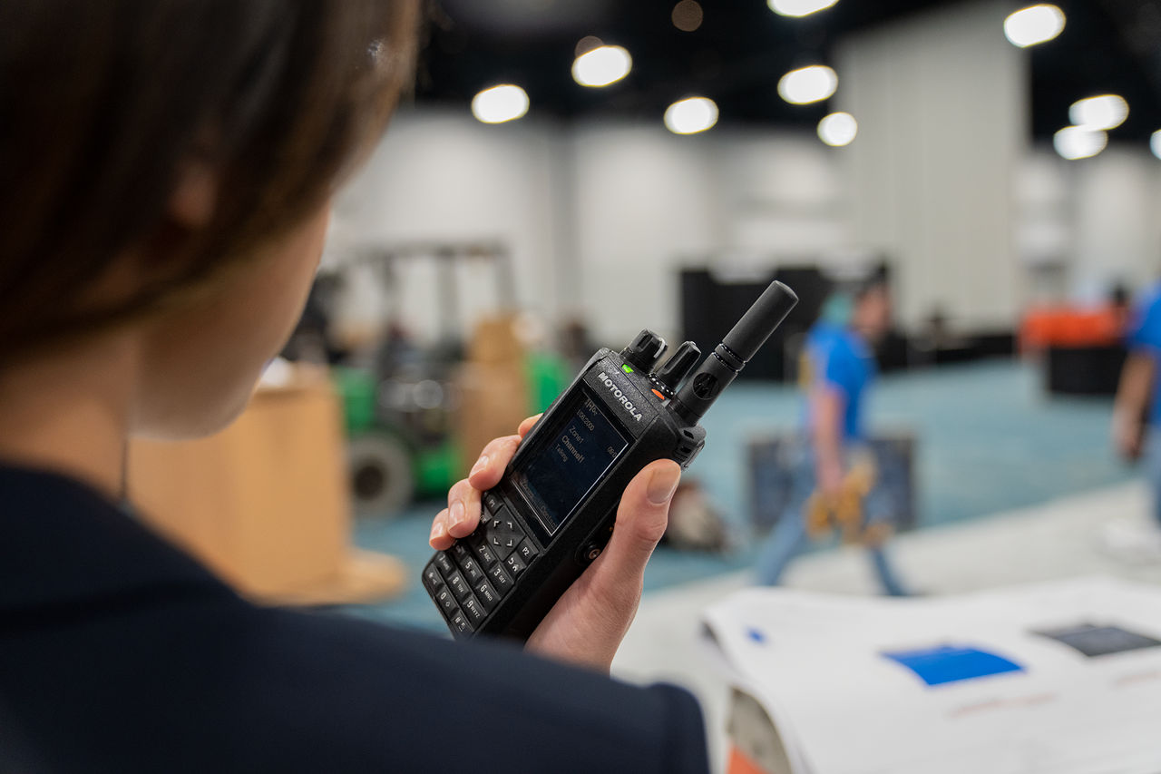 Hotel conference worker using a two-way radio